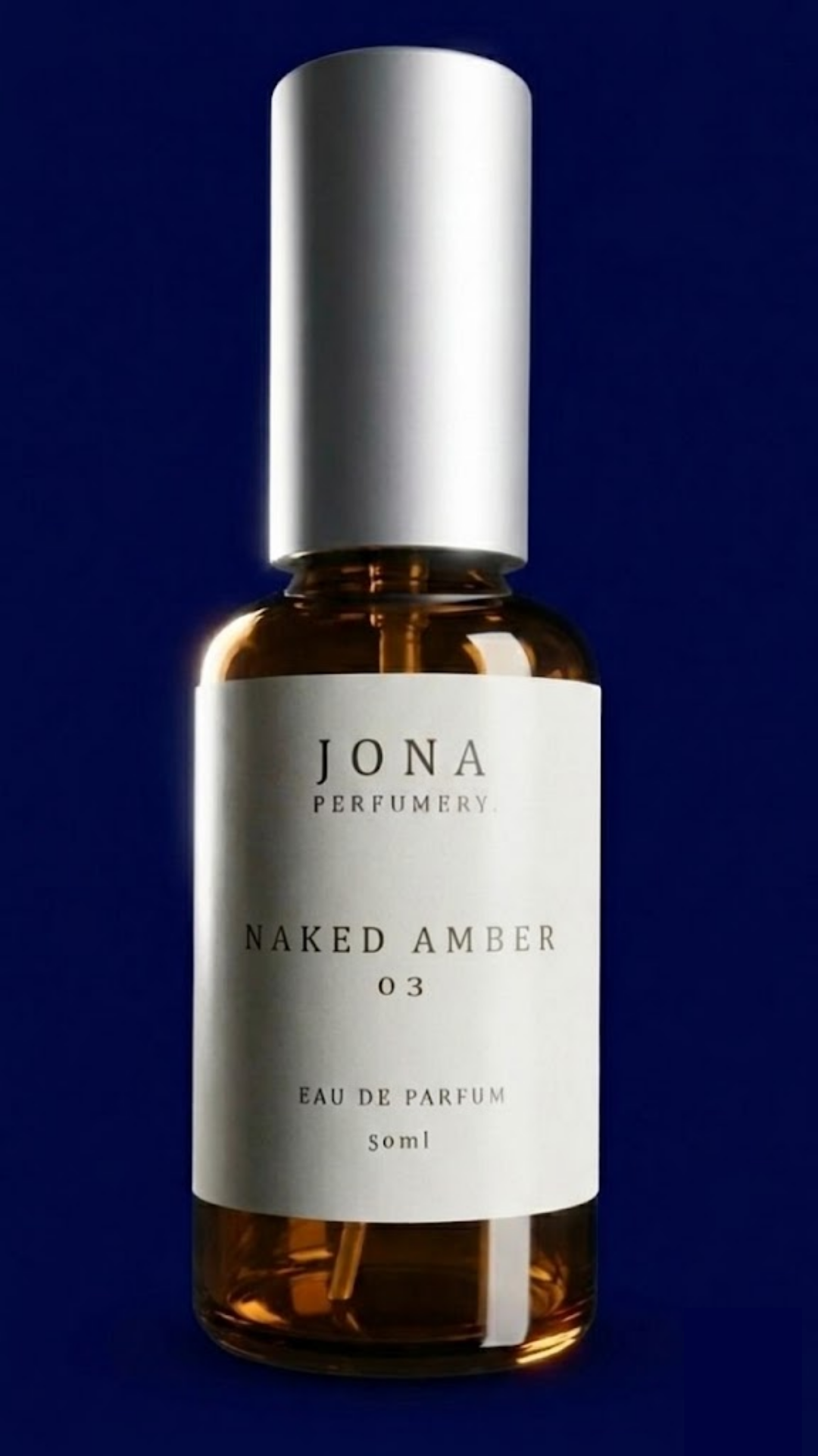 בקבוק בושם בצבע אמבר עם פקק כסוף של JONA Perfumery - Naked Amber 03
